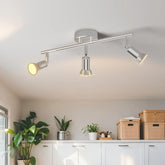 Modern ceiling light fixture in a room with plants and storage boxes.